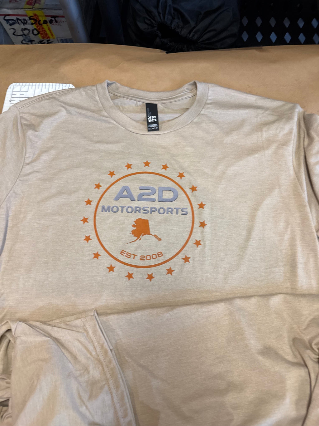 A2D Motorsports t-shirt in sand with orange and grey Stars and State Alaska logo
