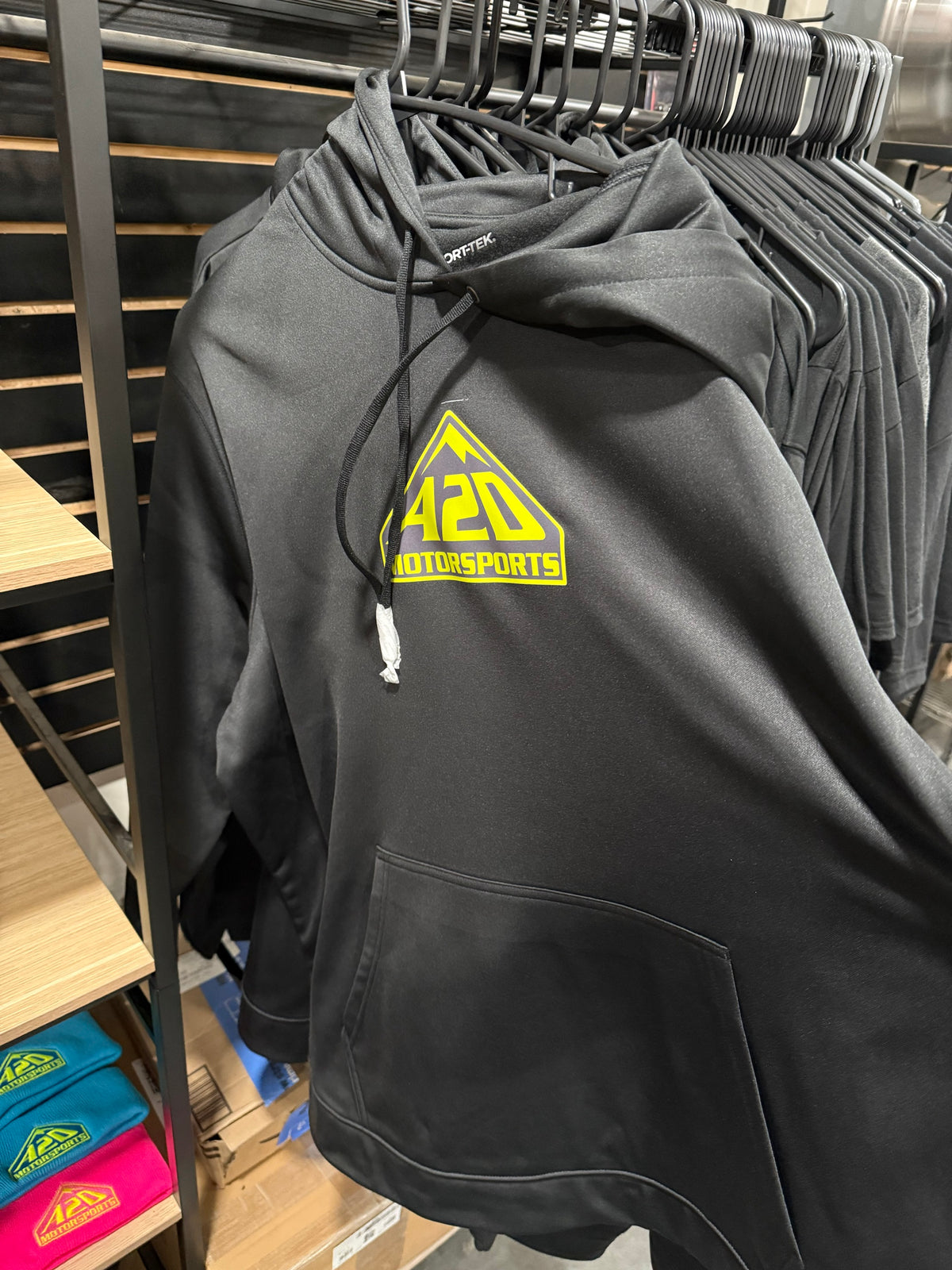 A2D Motorsports black hoodie with neon yellow mountain logo on the rack