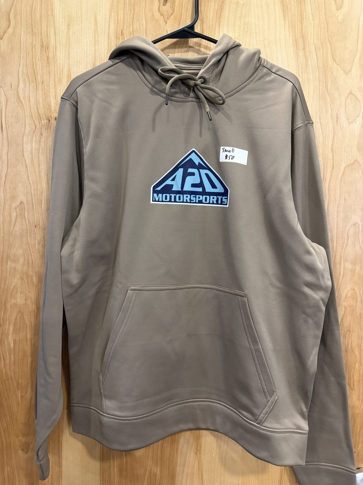 A2D Motorsports sand hoodie with navy and electric blue mountain logo, hanging