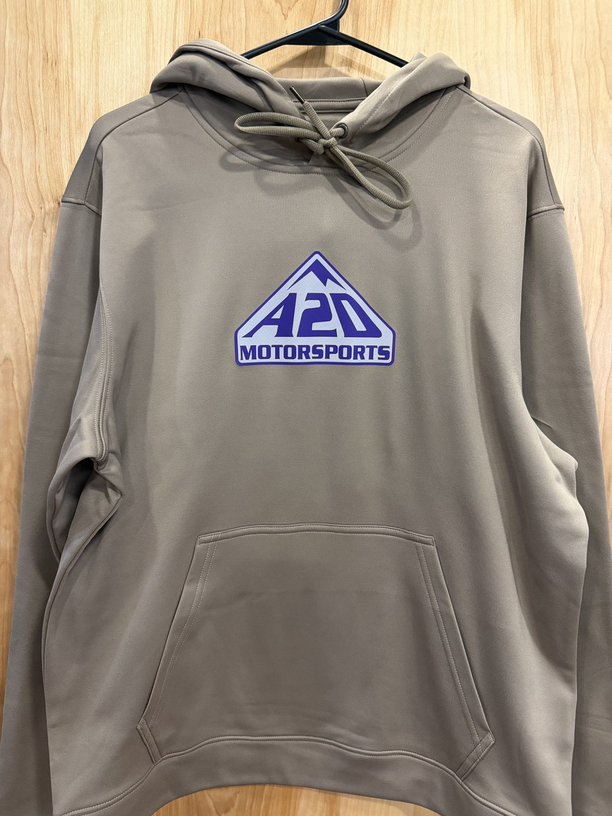 A2D Motorsports sand hoodie with purple and white mountain logo, hanging