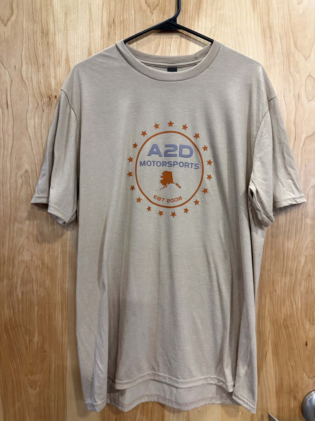 A2D Motorsports sand t-shirt with orange Stars and State Alaska logo, front