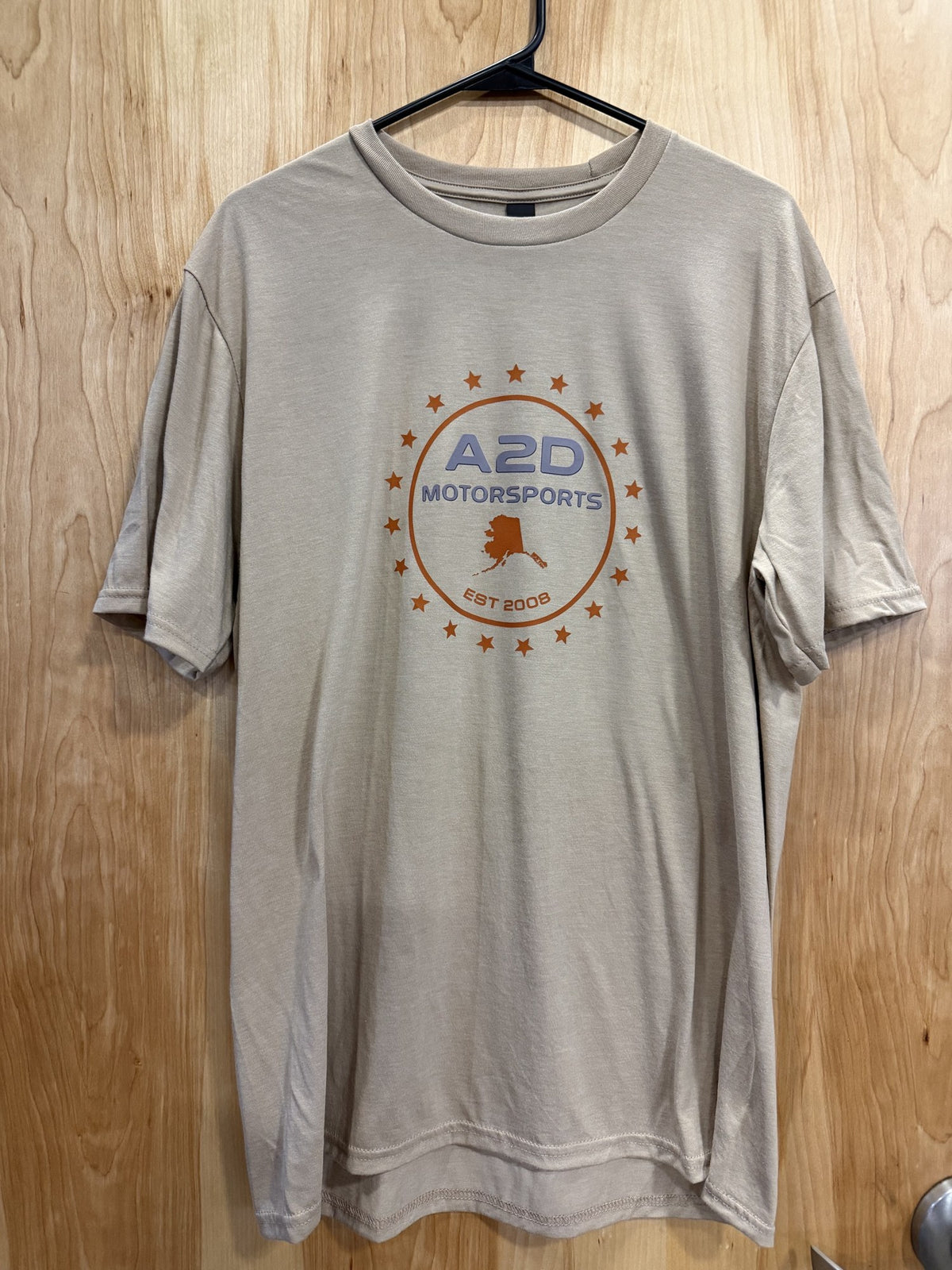 A2D Motorsports sand t-shirt with orange Stars and State Alaska logo, front